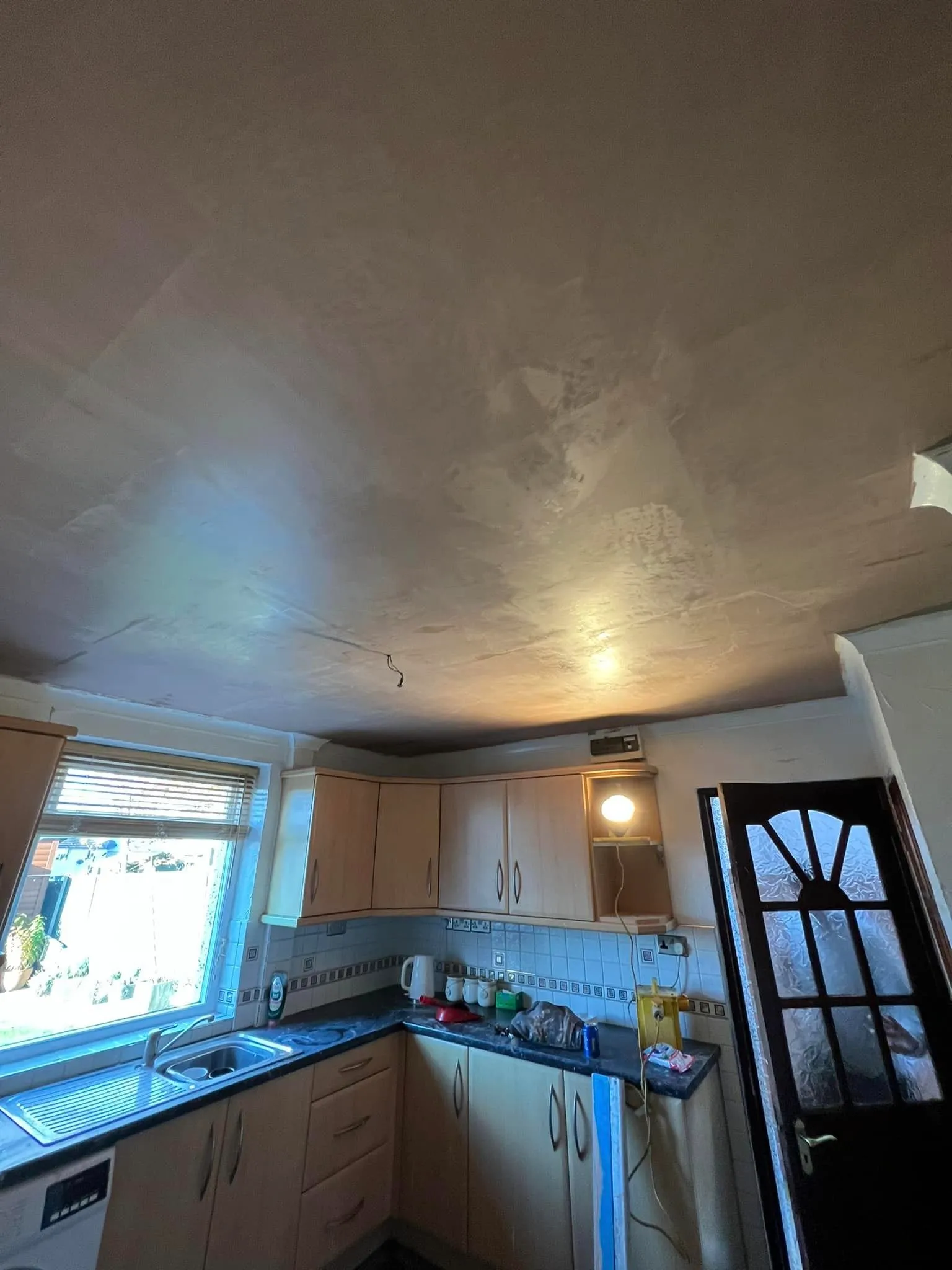 A kitchen that has a lot of white paint on the ceiling.